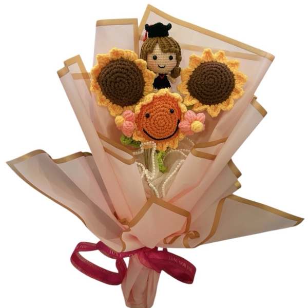 Crocheted sunflower bouquet with a small doll figure and pink wrapping