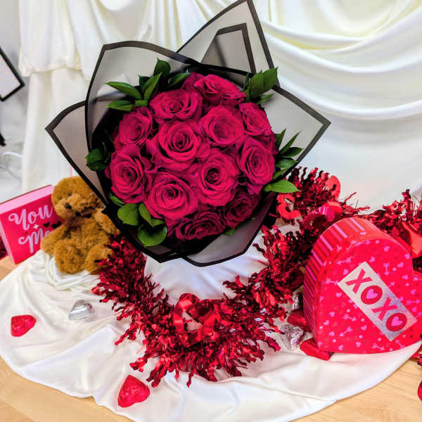 Bouquet of hot pink roses with a teddy bear and heart-shaped gift boxes