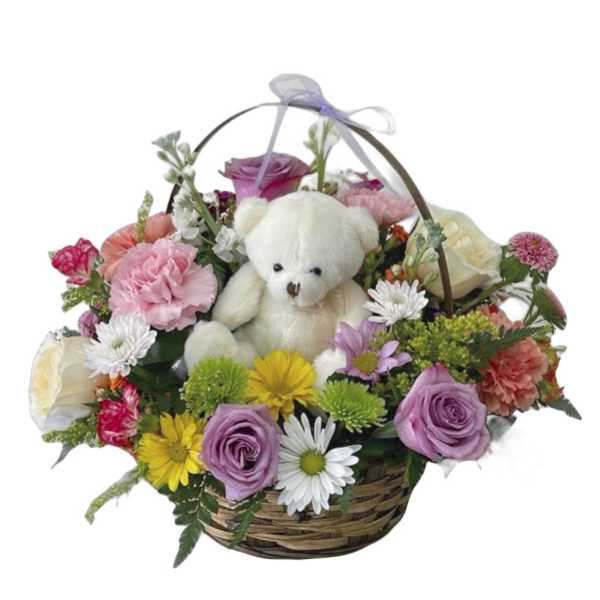 Basket arrangement with a teddy bear surrounded by mixed flowers