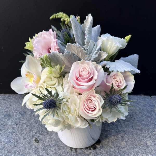 Pink roses and white orchids in a white vase