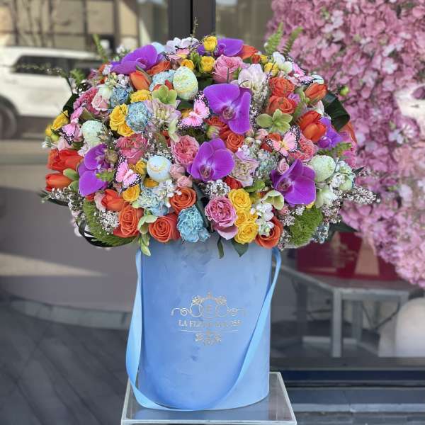 Large mixed bouquet in a blue hatbox with purple orchids and roses