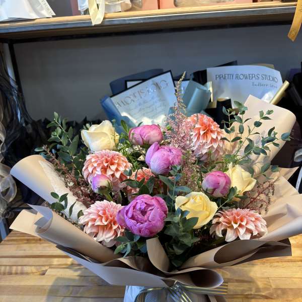 Bouquet of pink and cream flowers wrapped in paper