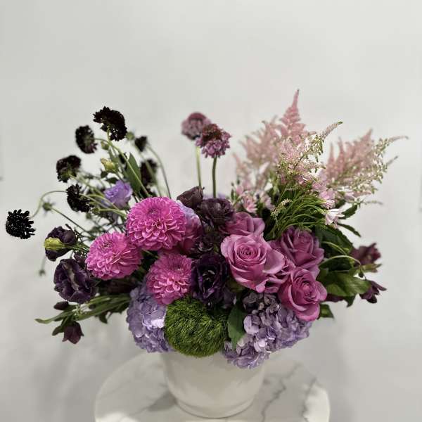 Pink and purple mixed bouquet in a white vase