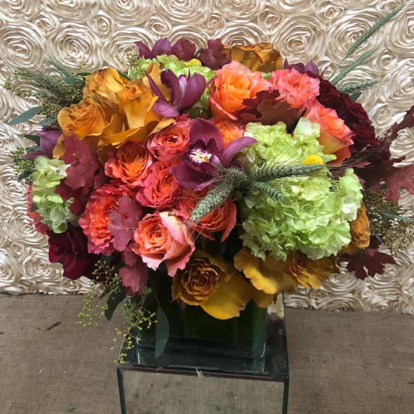 Bouquet of roses, orchids, and hydrangeas in a glass vase