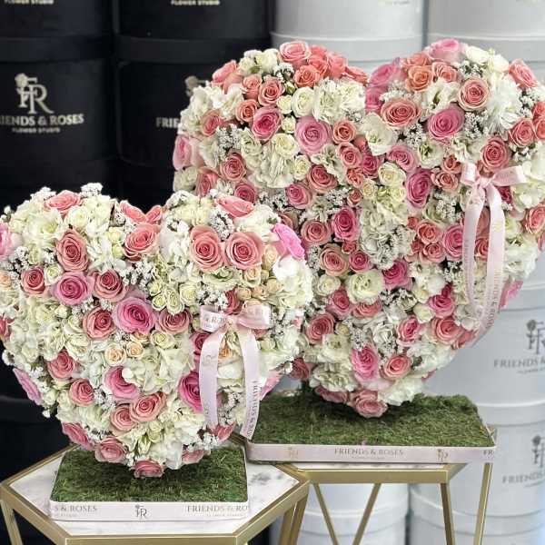 Heart-shaped rose arrangements in pink and white on gold stands