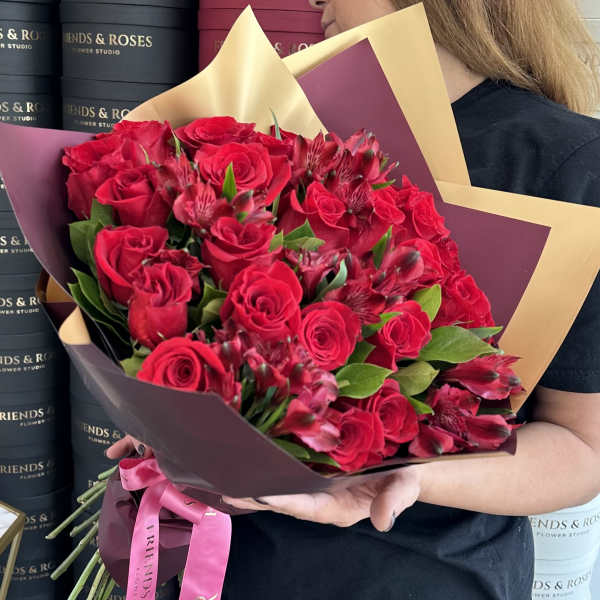 Bouquet of red roses and red alstroemeria wrapped in burgundy and gold paper