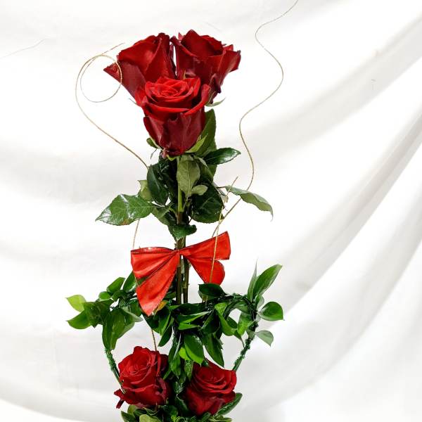 Tall arrangement of red roses in a terracotta pot with a red bow