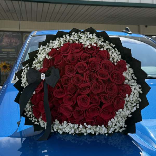 Large bouquet of red roses with white baby's breath and a black ribbon