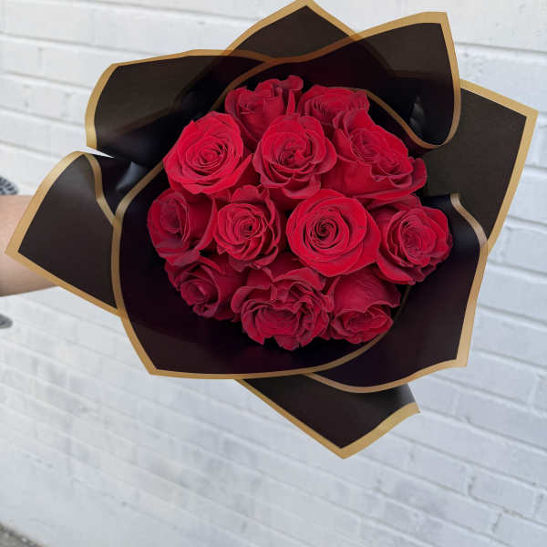 Bouquet of red roses wrapped in black and gold paper