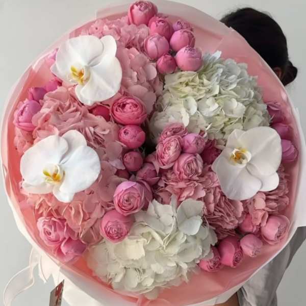 Round bouquet of pink and white flowers with orchids and hydrangeas