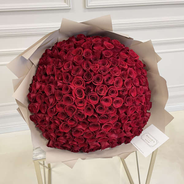 Large bouquet of red roses wrapped in beige paper
