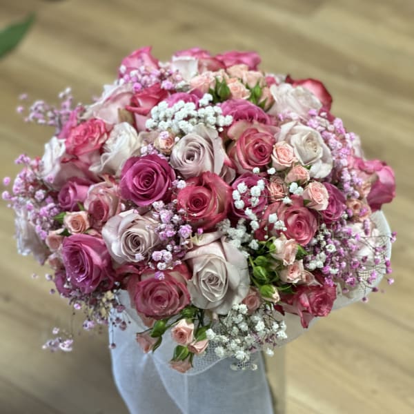 Round bouquet of pink and white roses with baby's breath