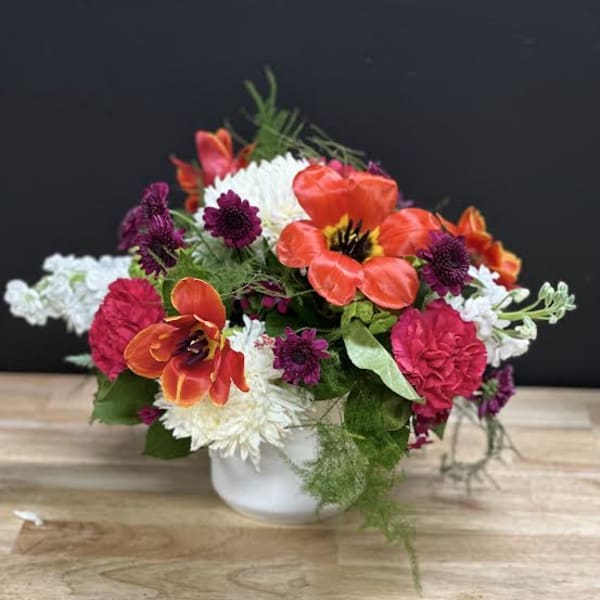 Colorful mixed flower arrangement in a white vase