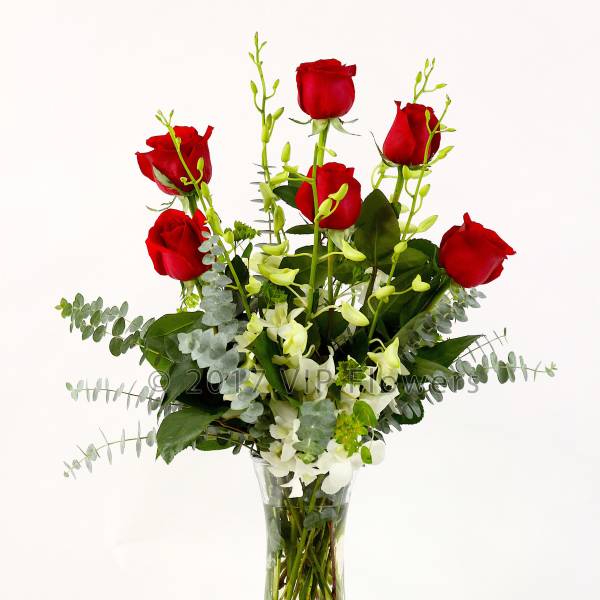 Red roses and white orchids in a clear glass vase