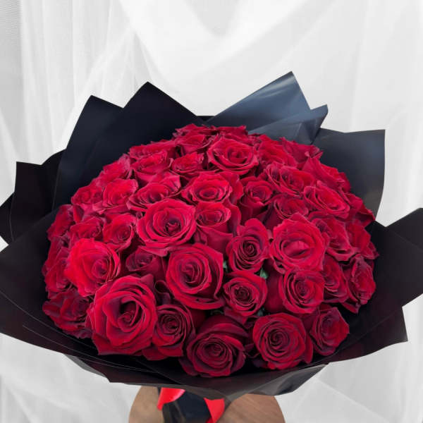 Bouquet of red roses wrapped in black paper