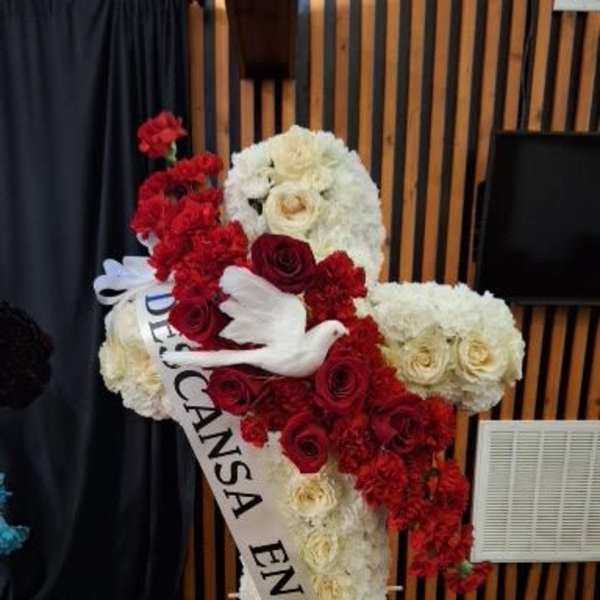 Large red and white floral tribute with a white dove and sash