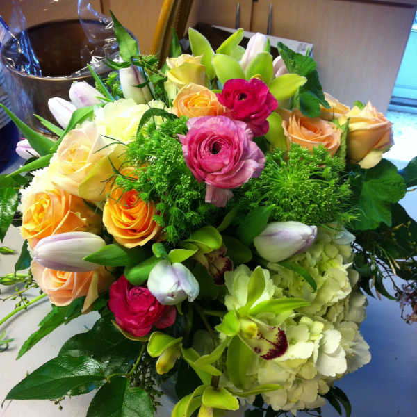 Bouquet of roses, tulips, orchids, and hydrangeas in pink, peach, and green