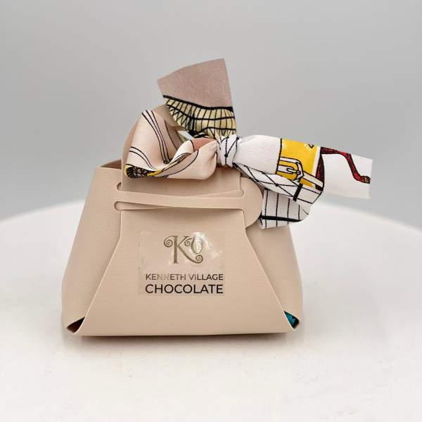 Beige chocolate gift box tied with a patterned ribbon