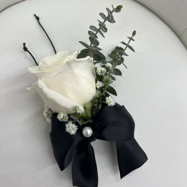 White rose boutonniere with black ribbon and pearl accent