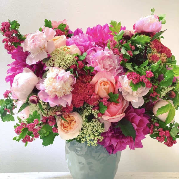 Pink and peach floral arrangement in a blue vase