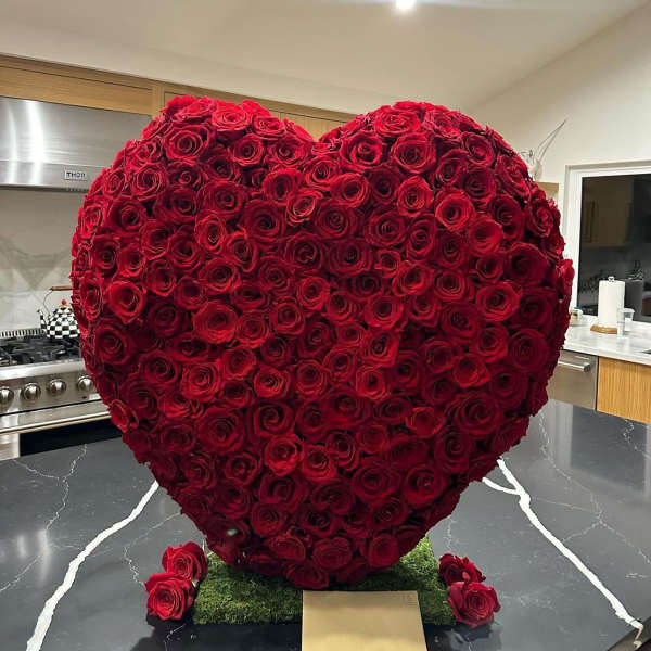 Heart-shaped arrangement of red roses on a kitchen counter