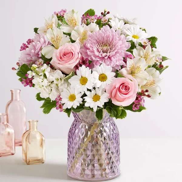 Pink and white mixed bouquet in a textured glass vase.
