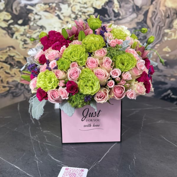 Pink and lime green rose arrangement in a gift box