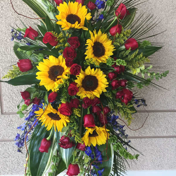 Standing floral spray with sunflowers and red roses