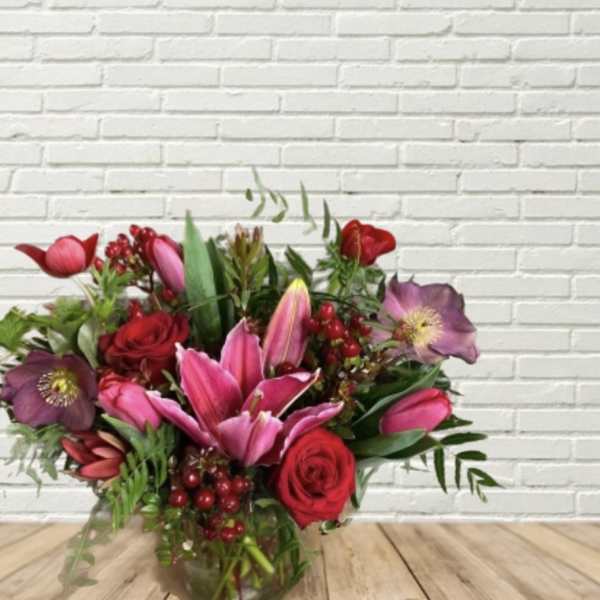 Bouquet of pink lilies and red roses in a glass vase