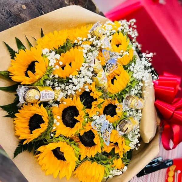 Bouquet of sunflowers with baby’s breath and chocolate candies wrapped in brown paper