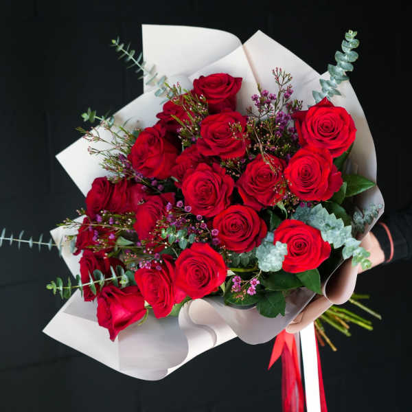 Bouquet of red roses wrapped in white paper