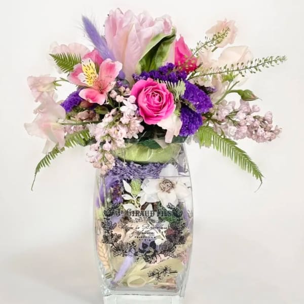 Pink and purple floral arrangement in a clear glass vase