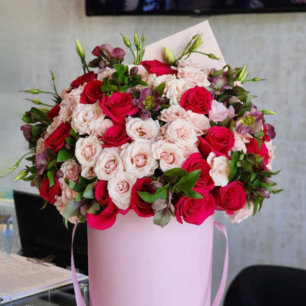 Bouquet of pink and red roses in a pink hatbox