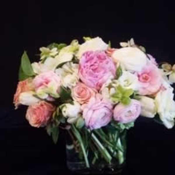 Pink and white roses arranged in a glass vase