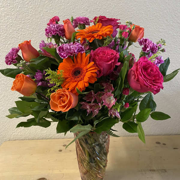 Bouquet of orange and pink flowers in a clear glass vase