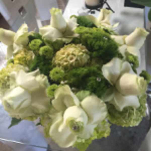 Round bouquet of cream roses and green blooms with jeweled accents in a compact arrangement