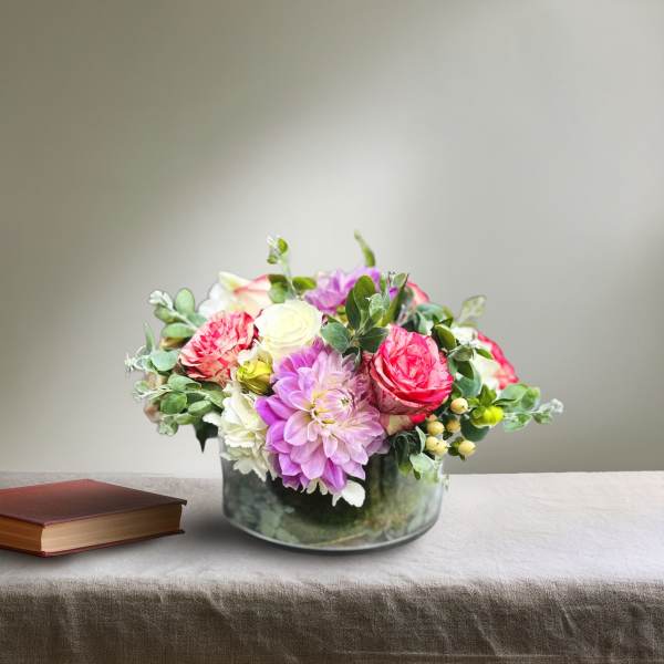 Mixed pink and white flowers arranged in a glass bowl vase