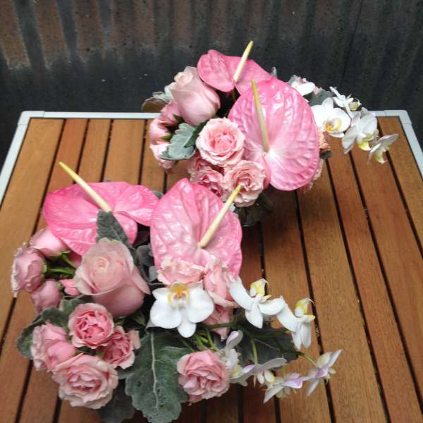 Pink roses and white orchids arranged with pink anthuriums