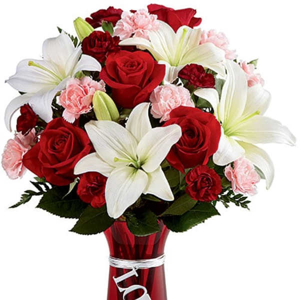 Red roses and white lilies in a red vase with a LOVE charm