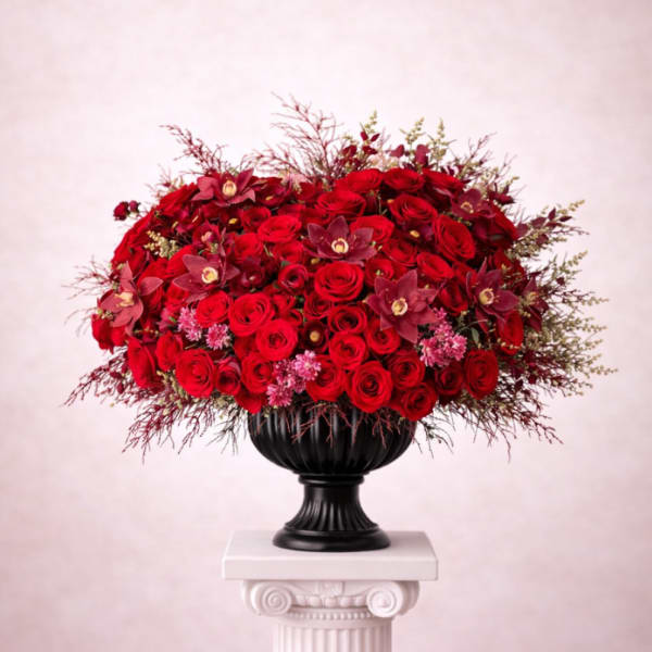 Large red rose arrangement in a black urn vase