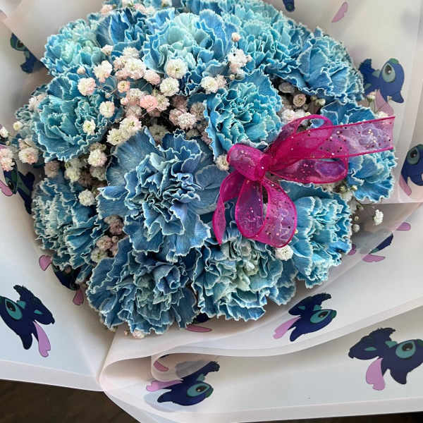 Blue carnation bouquet with baby's breath and a pink ribbon