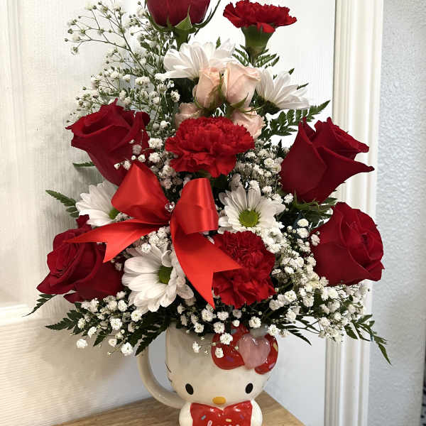 Red roses and white daisies arranged in a Hello Kitty mug with a red bow.