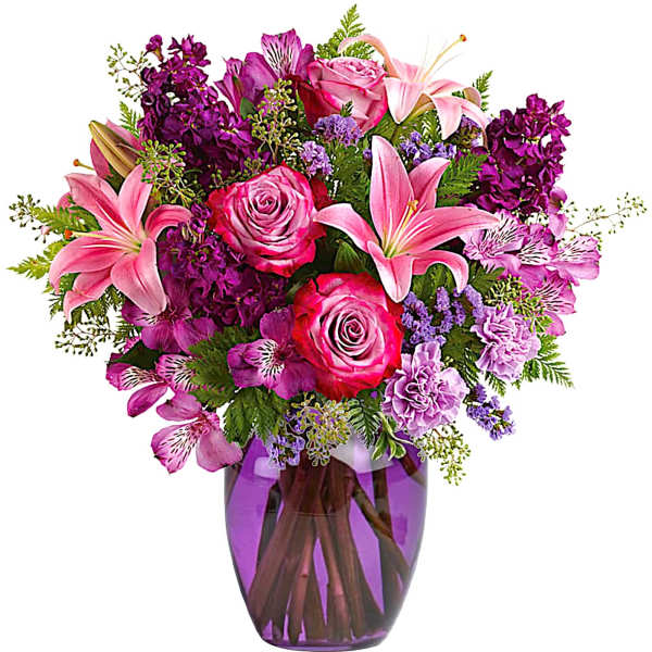 Pink and purple mixed bouquet in a purple glass vase