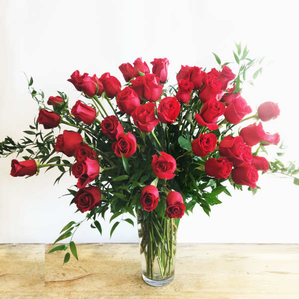 Red roses arranged in a clear glass vase
