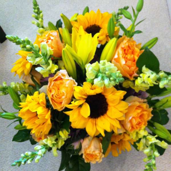 Bouquet of yellow sunflowers, orange roses, and lilies