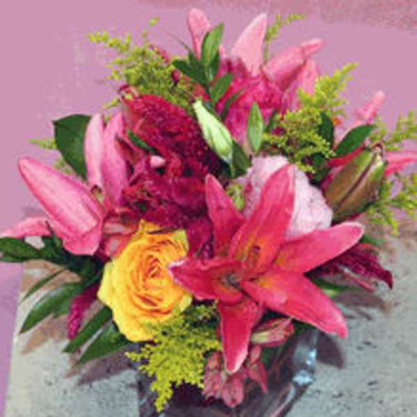 Pink lilies and a yellow rose in a glass vase