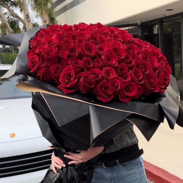 Large bouquet of red roses wrapped in black paper