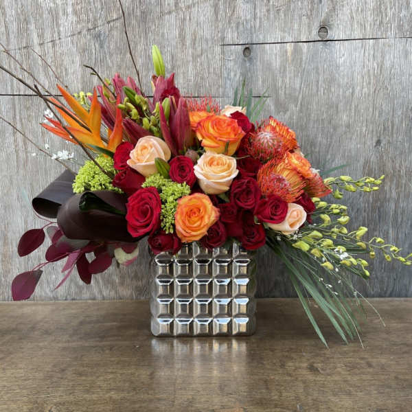 Mixed bouquet of red and orange roses in a silver vase