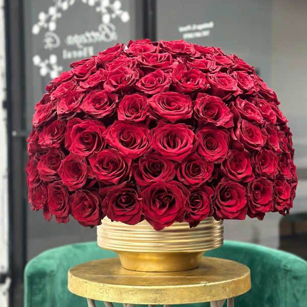 Large dome of red roses in a gold vase