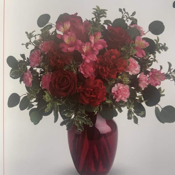 Red and pink bouquet in a red glass vase